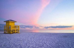 pink sunset on beach with lifeguard stand at siesta key for visit sarasota feature