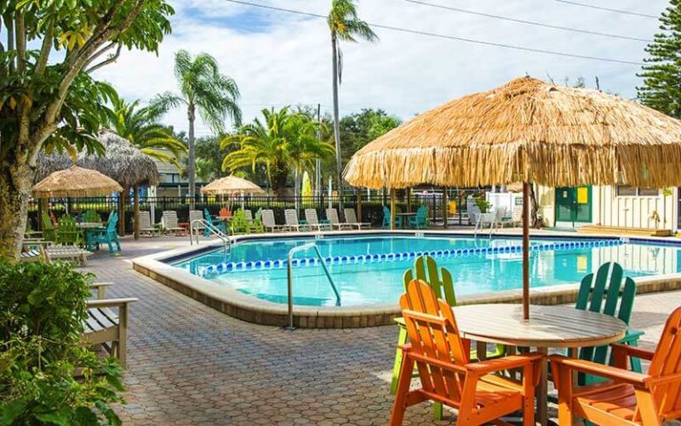 pool area with tiki umbrellas and colorful chairs at st petersburg madeira beach koa holiday