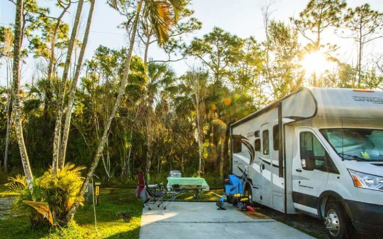 rv parked with patio area trees and stroller at naples marco island koa holiday