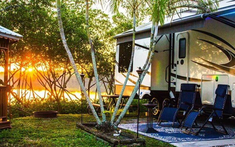 rv trailer with patio area, trees and sunset at st petersburg madeira beach koa holiday