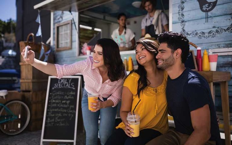 friends taking selfie from mobile phone at food truck at food trucks heaven kissimmee