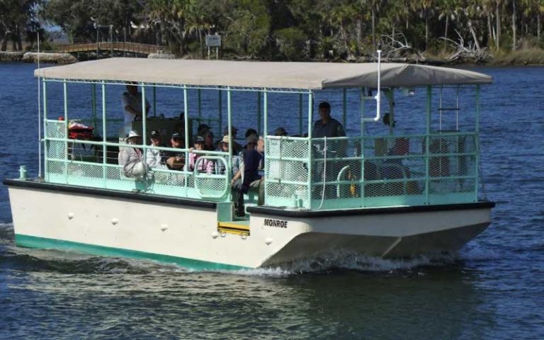 tour boat with white canopy on river at crystal river preserve state park