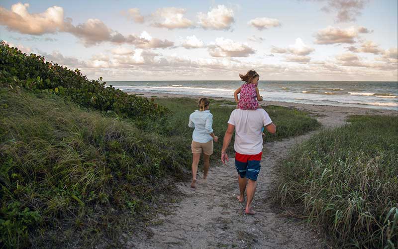 family walking on coastal path to beach for unplugging on your florida vacation enjoy florida blog