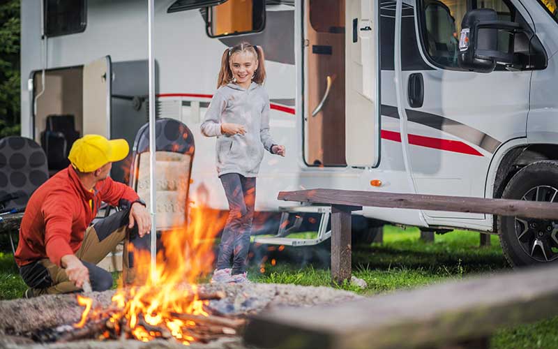 father and daughter next to rv with campfire for enjoy florida blog