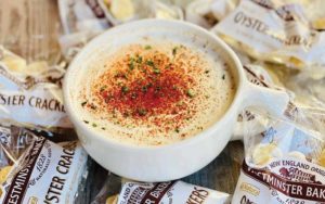 bowl of new england style clam chowder with paprika and oyster crackers at celebration town tavern