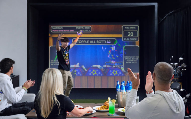 boy scores large screen game at topgolf swing suites