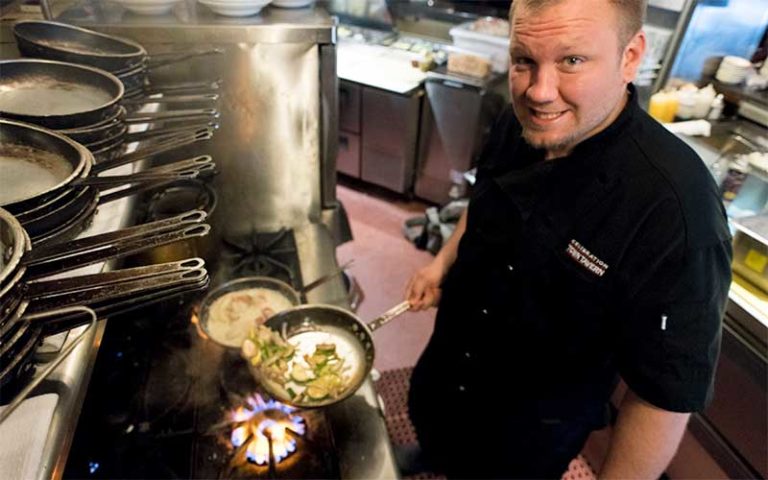 chef cooking seafood in pans over range at celebration town tavern