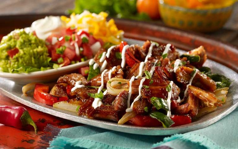 colorful entree of carnitas fajitas with sides at uncle julios mexican restaurant icon park orlando