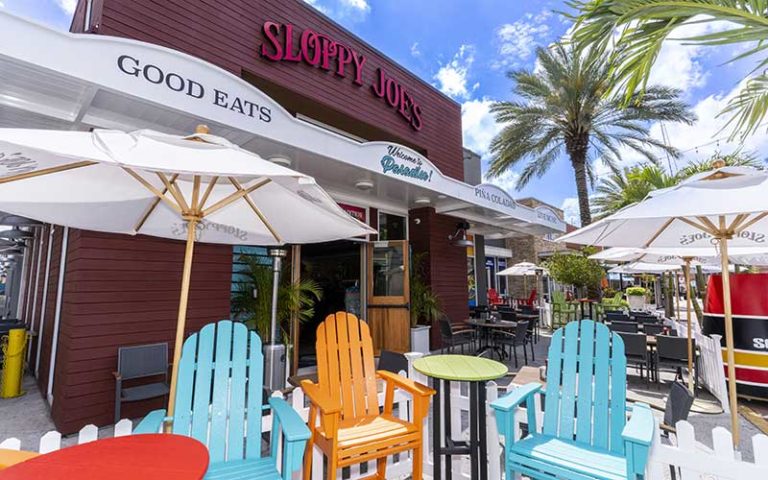 front exterior of restaurant with colorful lounge chairs at sloppy joes icon park orlando