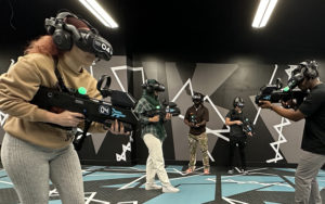 group wearing vr tech with guns playing combat game at max action arena icon park