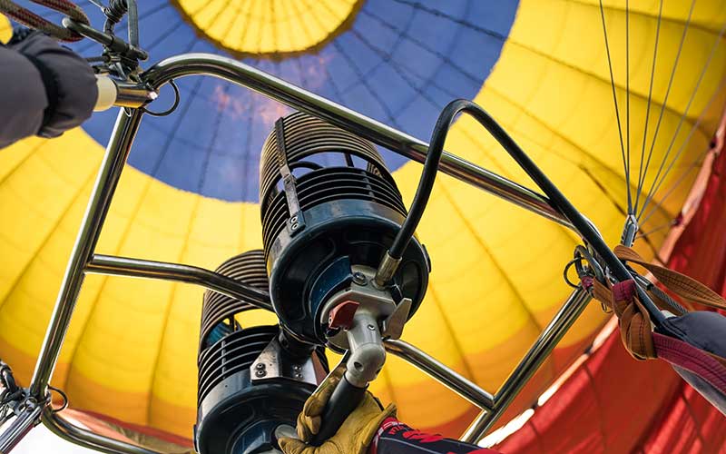 hot air balloon burner shot from below with flames and colorful inflated balloon for enjoy florida blog
