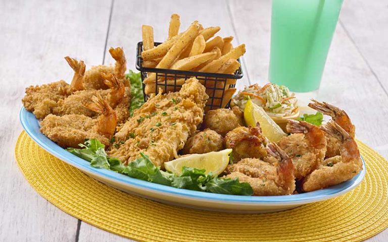 large seafood platter with french fries and blue cocktail at sloppy joes icon park orlando