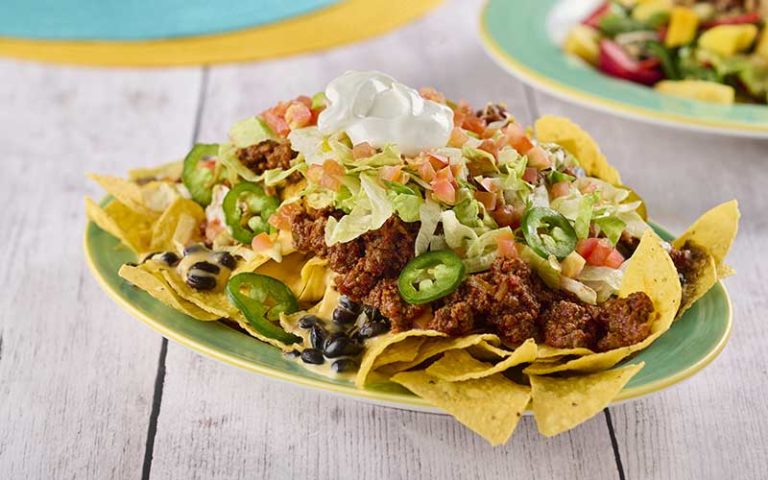 loaded nachos with jalapeno and sour cream on tabletop at sloppy joes icon park orlando