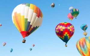 multiple colorful hot air balloons in clear blue sky for enjoy florida blog
