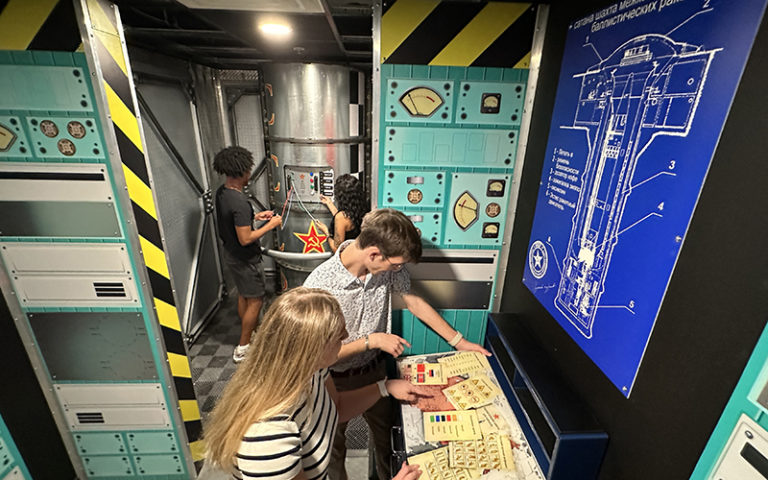 teens exploring escape room with blueprints at max action arena icon park