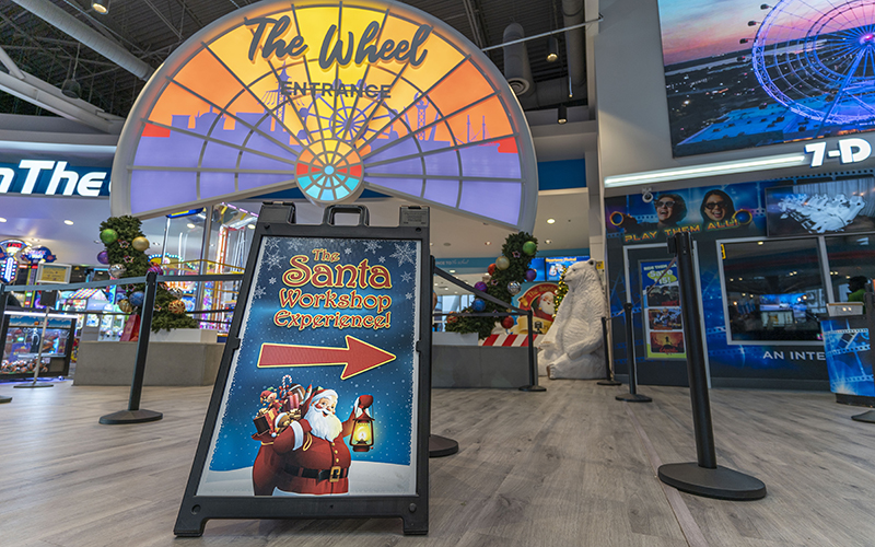 santa workshop sign with arrow in the wheel entrance building at icon park