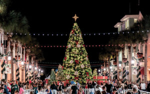 crowded market street with lights and christmas tree at night for now snowing event celebration town center