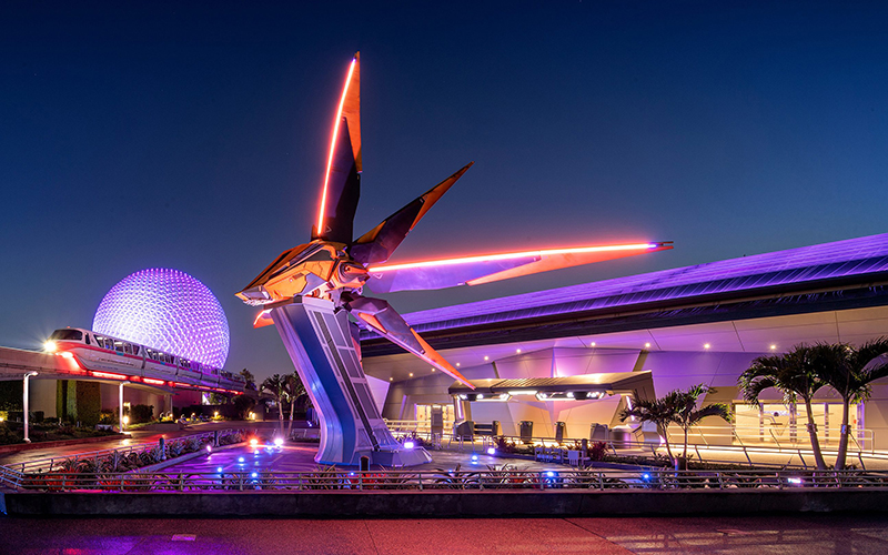 epcot globe and monorail with purple and red lighting and spaceship sculpture at cosmic rewind guardians of the galaxy epcot disney park