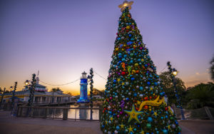 seaworld gate and lighthouse with christmas tree lit up at dusk at seaworld orlando