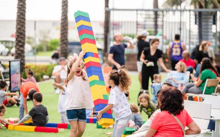 kids playing with blocks on lawn outside mall at dania pointe fort lauderdale