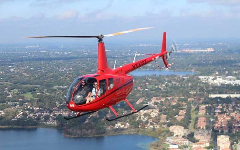 red helicopter flying with aerial view lakes and housing at orlando helicopter adventures kissimmee