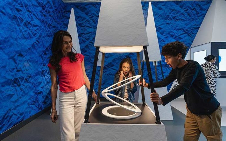 two kids and mom around optical illusion at paradox museum miami