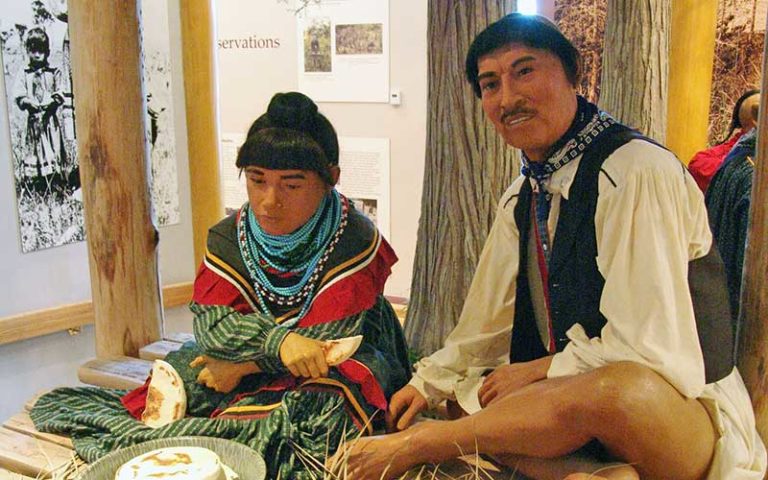 father and son native american figures cooking over fire in museum diorama exhibit at ah-tah-thi-ki museum