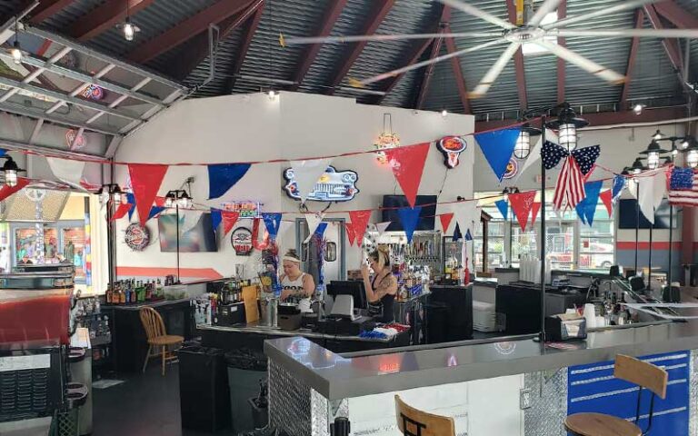 bar garage interior with large ceiling fan and dining area with servers and bar at bobbys garage bar in old town