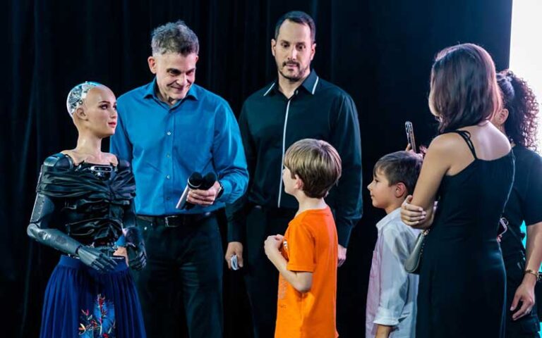 group of people on stage meeting sophia robot at roboland orlando