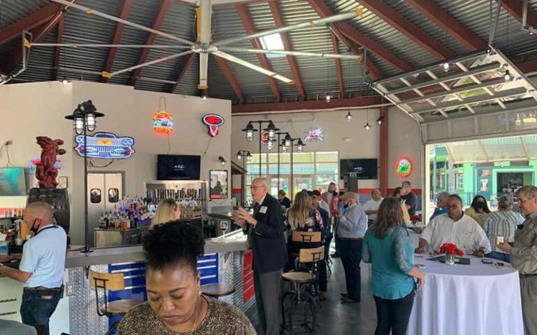 interior dining car area with customers at tables and large ceiling fan metal roof at bobbys garage bar in old town