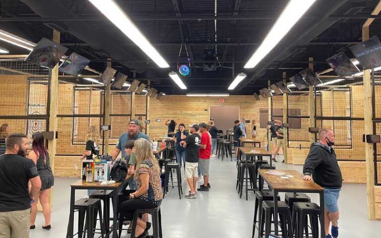 main floor of throwing room with tables and people waiting for their turn and having drinks at bigfoot axe throwing and rage room