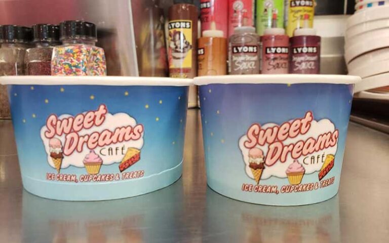 metal countertop with branded serving cups with toppings behind at sweet dreams cafe old town