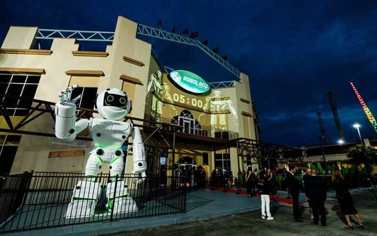 night exterior of roboland building with giant white robot statue and crowd at roboland orlando