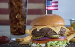 stacked deluxe burger with american flag fries and soda at shoneys kitchen and bar old town
