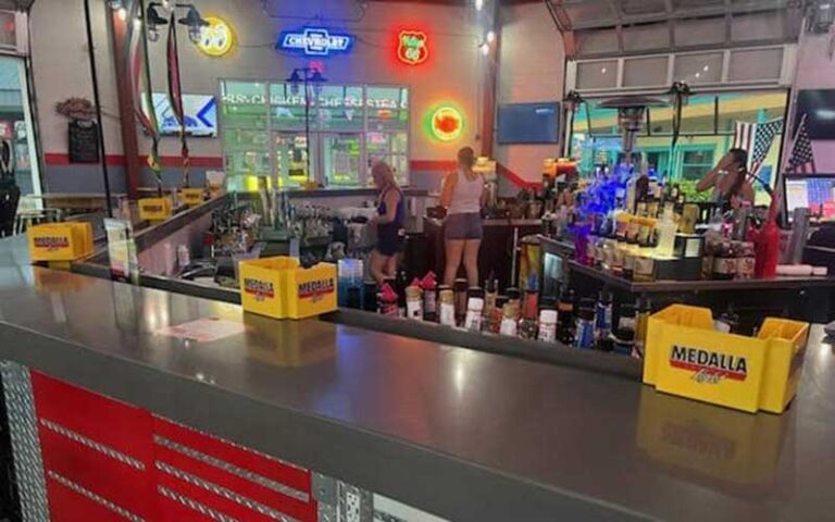 view over toolbox style bar of garage interior with bottles and servers at bobbys garage bar in old town