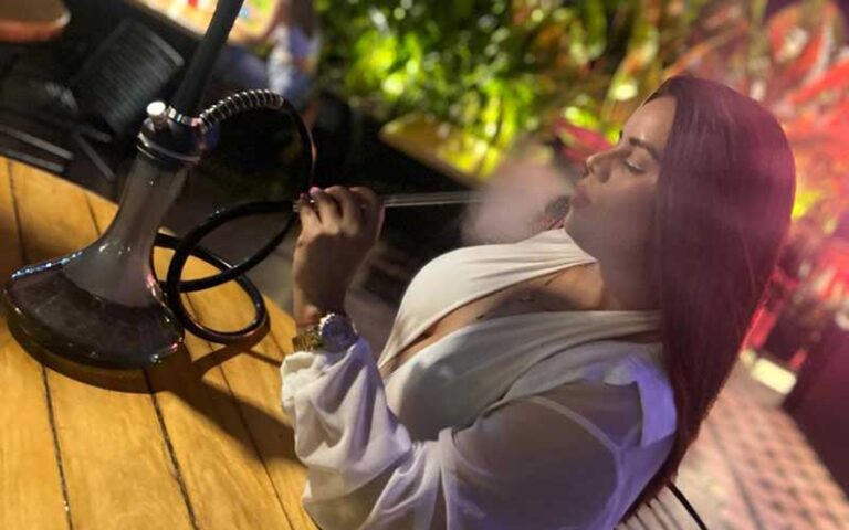 woman sitting at table smoking hookah in nightclub atmosphere at perfectos lounge orlando