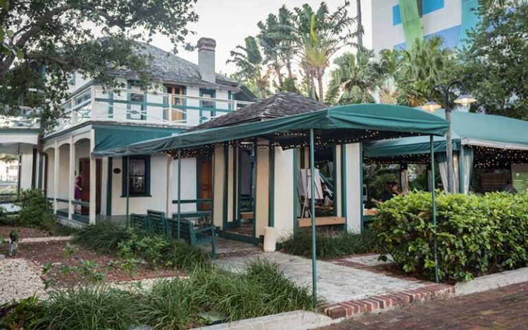 back patio garden of big house with green awnings at historic stranahan house museum ft lauderdale