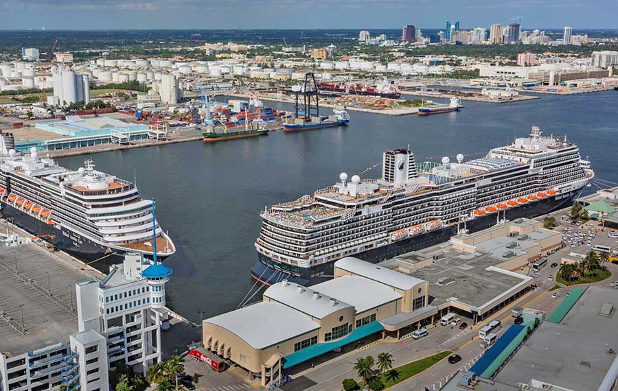 cruise ships and cargo ships docked with downtown skyline at port everglades
