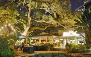 exterior at night of small theater with marquis and restaurant dining patio at enzian theater