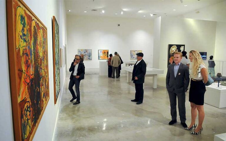 formally attired attendees looking at art exhibits on walls at nsu art museum ft lauderdale