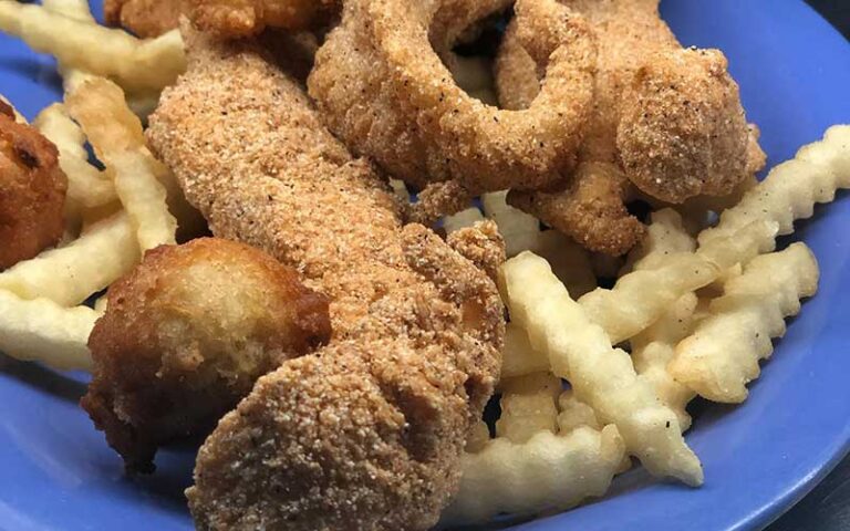 fried catfish hushpuppies and crinkle fries on blue plate at j l trents seafood grill jacksonville