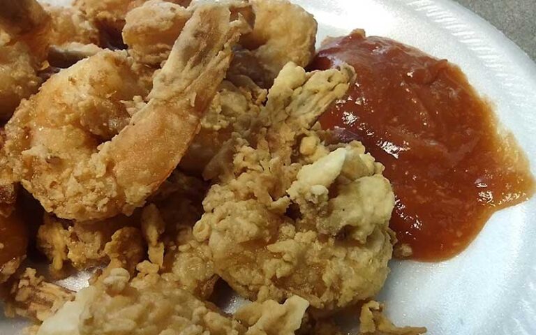 fried shrimp on paper plate with red sauce at southern charm jacksonville