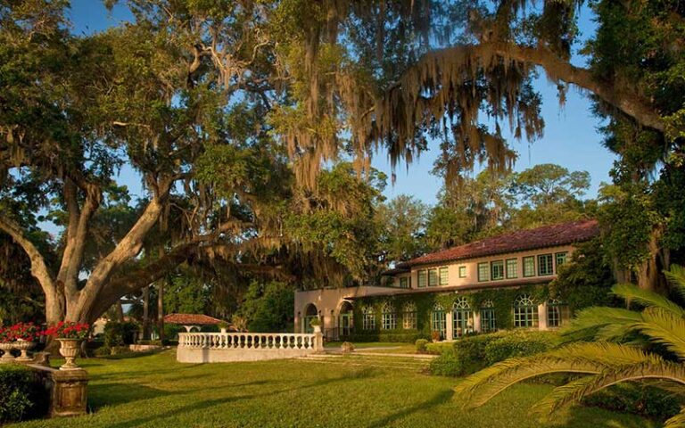 front exterior of hotel with oak trees at continental club orange park