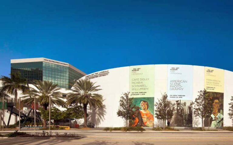 front exterior of round building with exhibit banners and palm trees at nsu art museum ft lauderdale