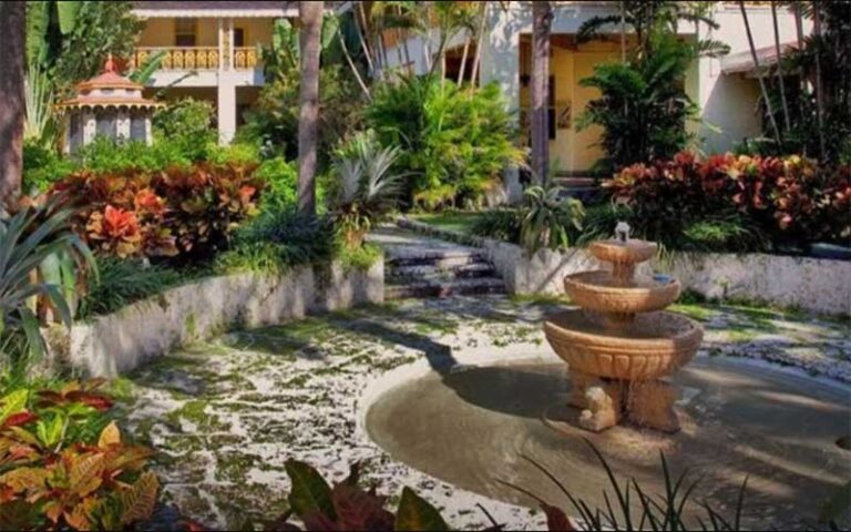 garden area with tiered fountain and colorful plants at bonnet house museum gardens ft lauderdale