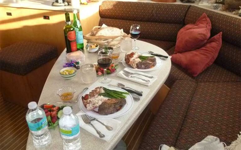 gourmet dinner on table in cabin of boat at now and zen sailboat charters jacksonville