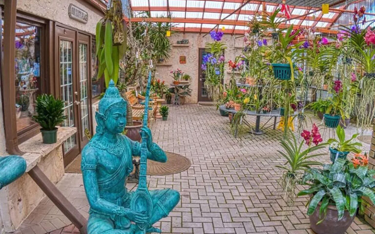 greenhouse patio with blue hindu statue and plants at r f orchid homestead
