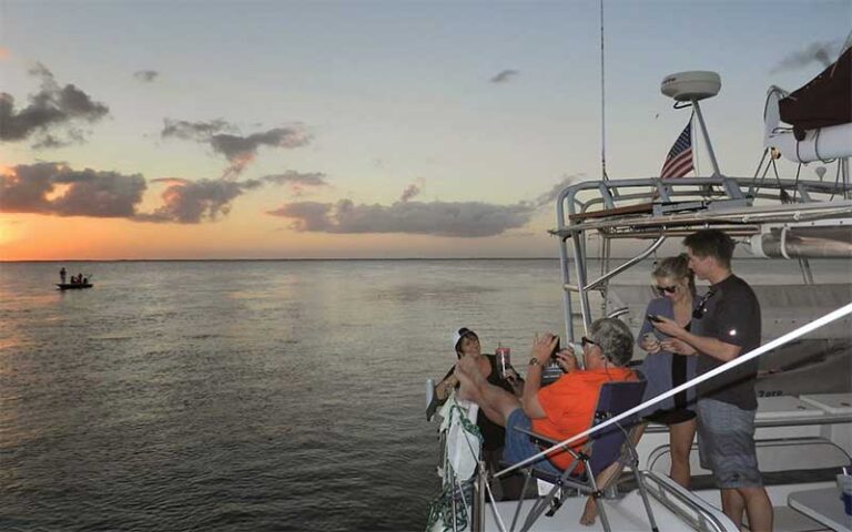 group watching sunrise from boat at now and zen sailboat charters jacksonville