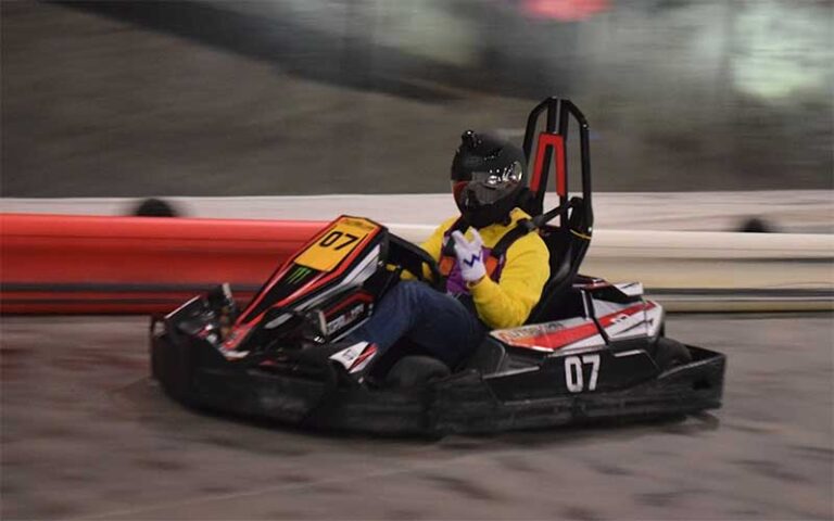 helmeted racer zipping along track in adult kart at autobahn indoor speedway events jacksonville