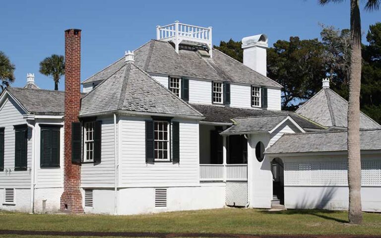 historic white house with black shutters and bricked chimney at kingsley plantation jacksonville